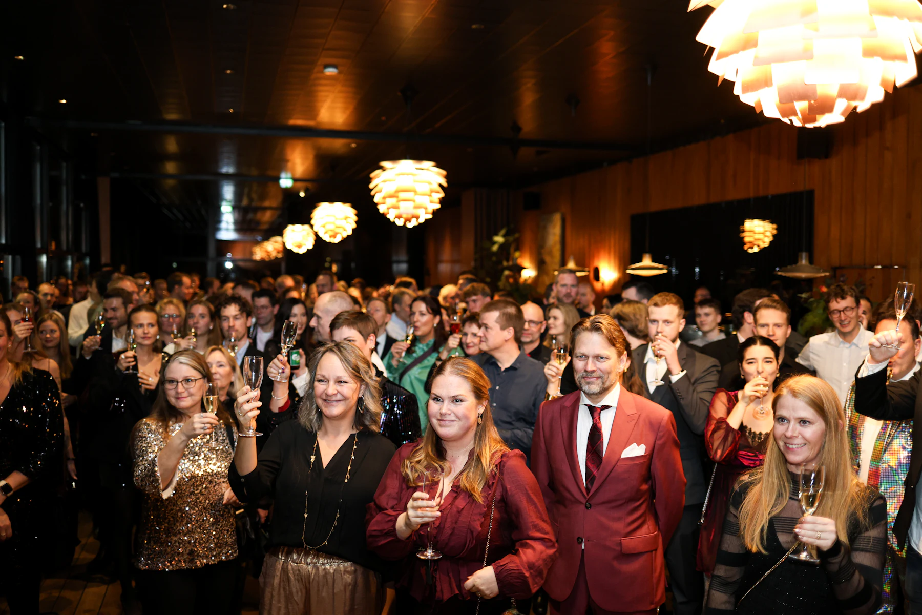 Volle zaal met feestende gasten onder kroonluchters