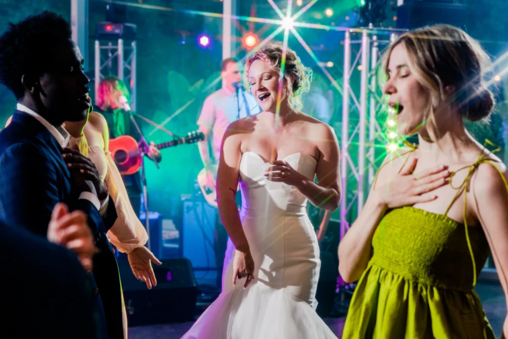Bruid zingt mee met vriendinnen onder het podiumlicht