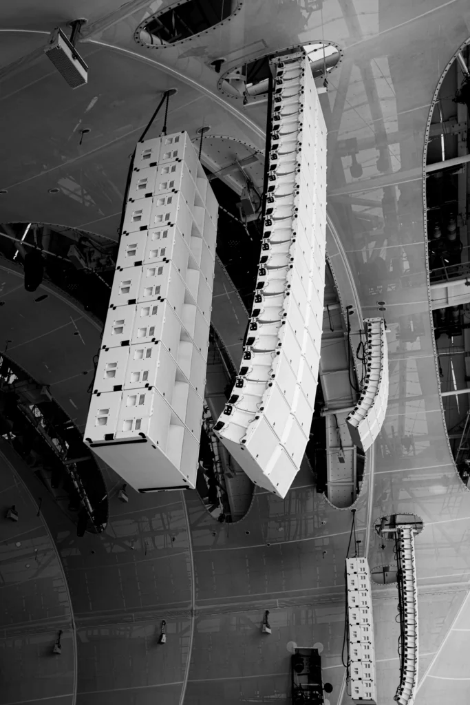 Speakers hangend aan een plafondconstructie, in zwart-wit